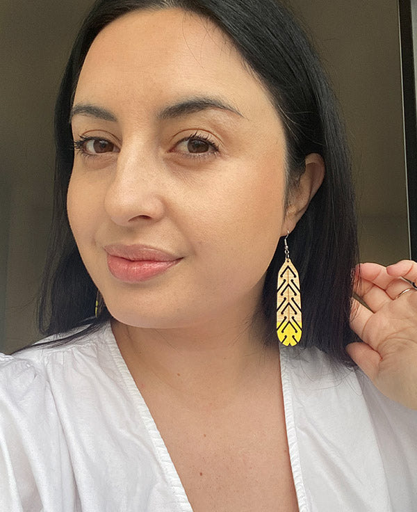Woman wearing huia earrings by Mako Design